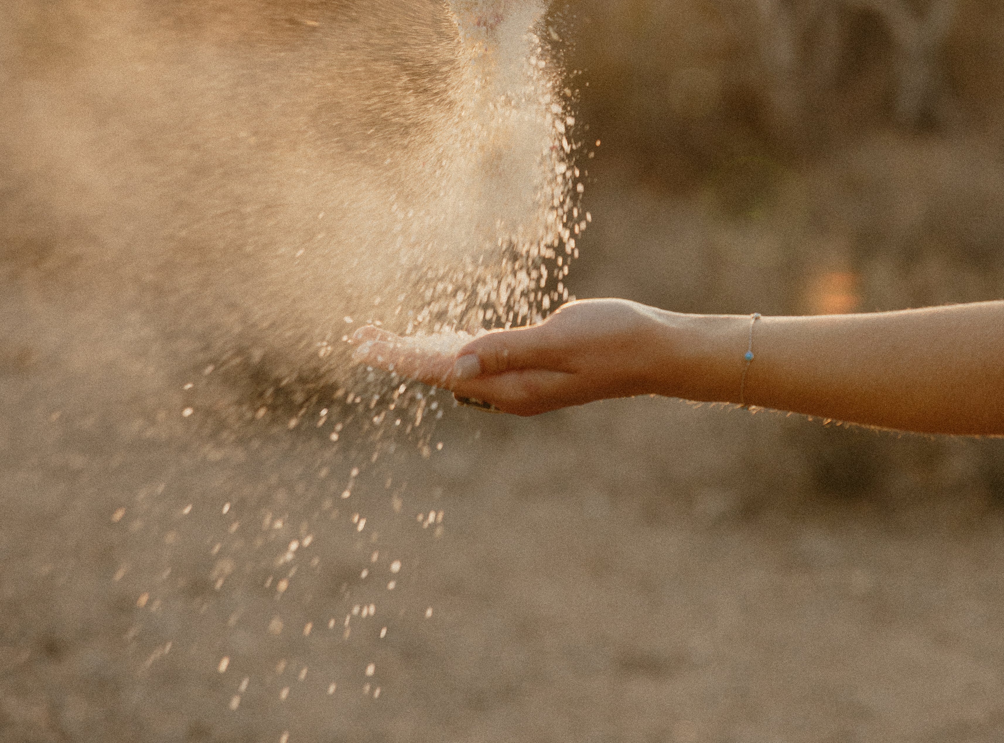 Image of arm and hand with milk bath blowing in wind