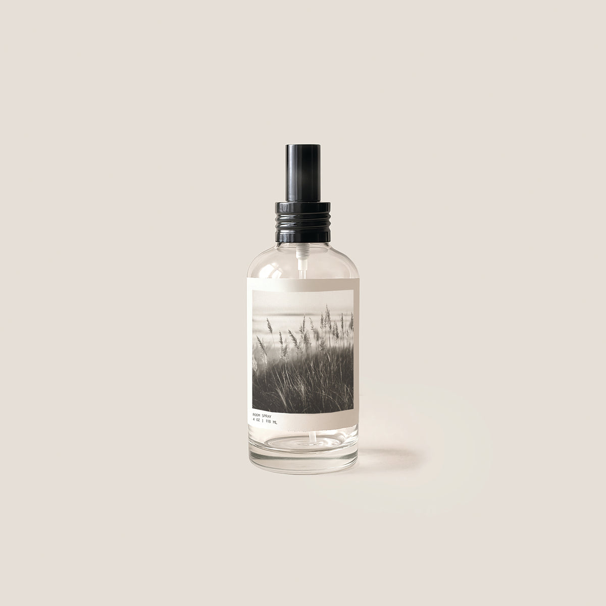 Image of glass bottle with black cap and label showing black and white coastal grasses