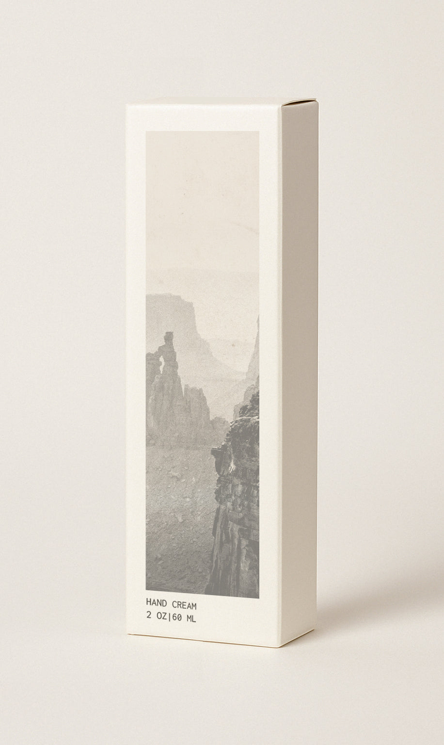 Off-white colored hand cream box featuring image of canyons.
