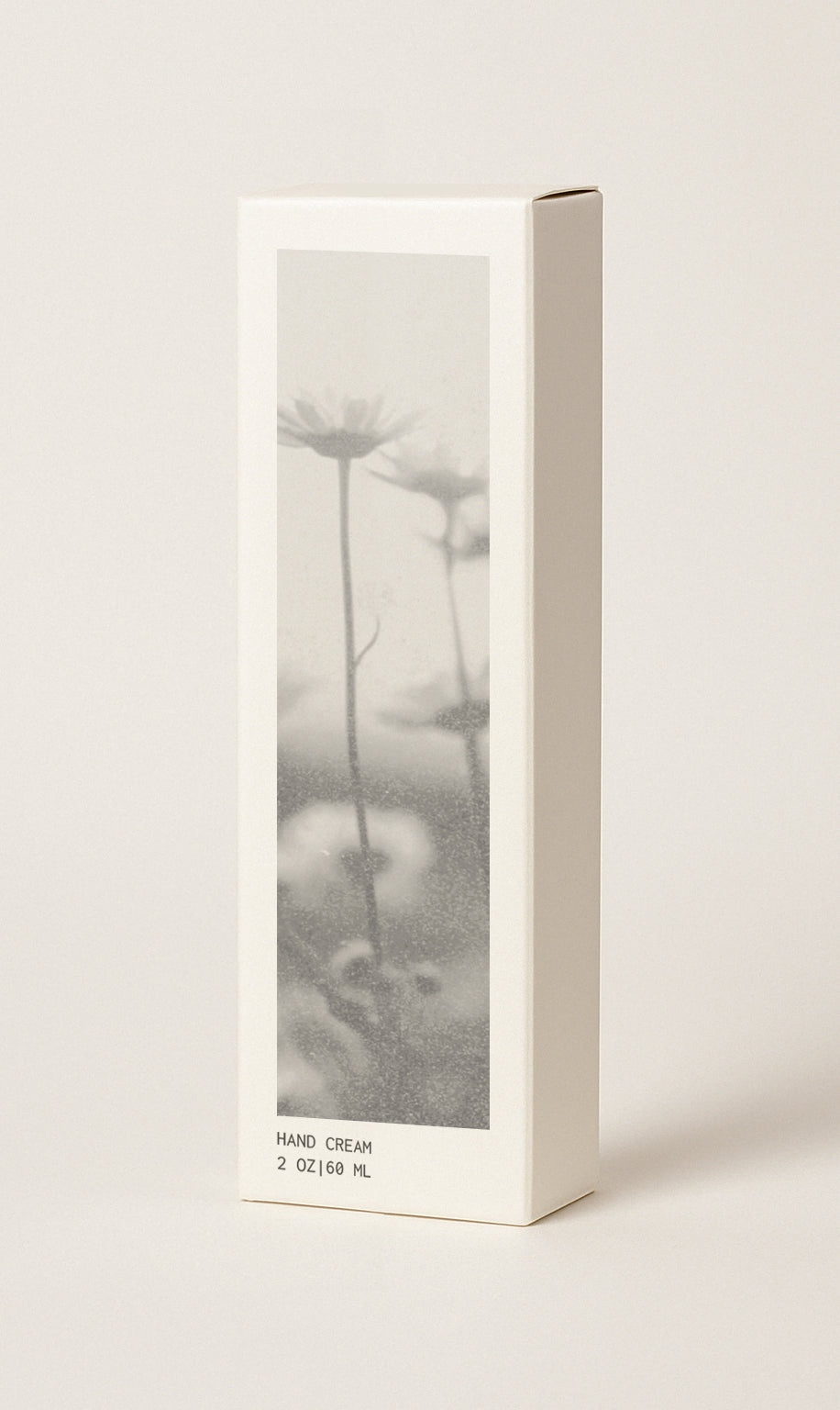Off-white colored hand cream box featuring black and white floral image on box