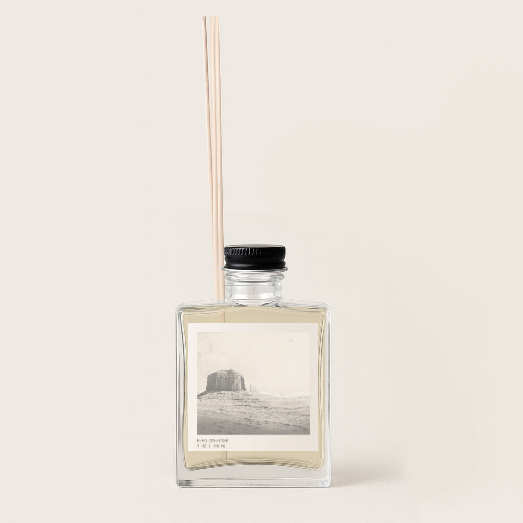 Image of rectangular glass diffuser bottle with archival sepia toned image on the front label. Diffuser bottle has black metal cap. 