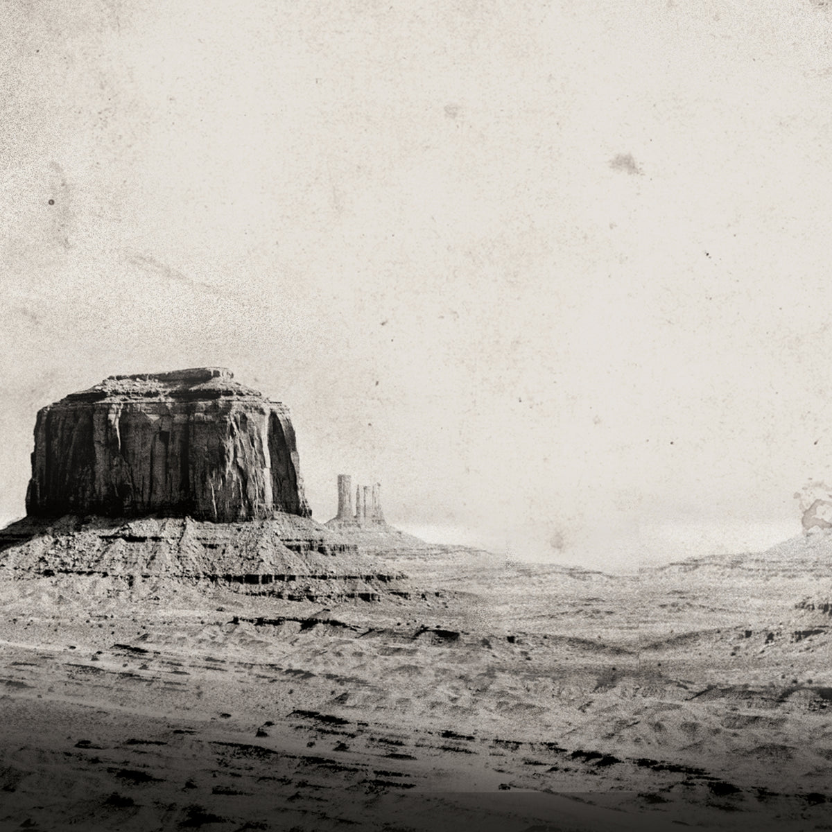 Vintage-style sepia-toned landscape photograph of a desert butte and rocky mesa formations under a pale sky, with a distressed, aged-paper texture.