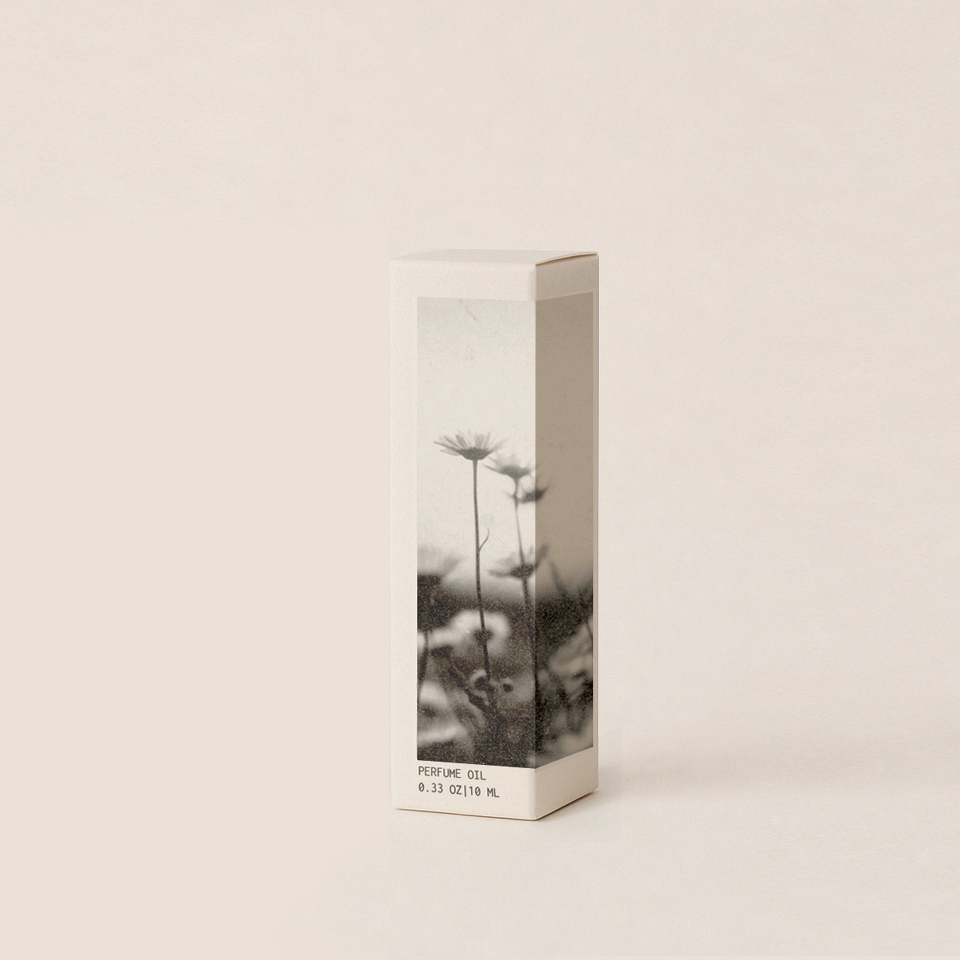 A cream colored perfume oil box with black and white flowers on it. Box reads 'Perfume Oil', displayed against a clean white background.